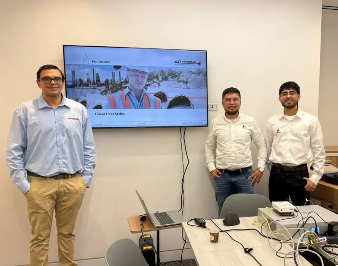 Integrantes del equipo de UBORA en una sesión de formación, frente a portátiles y una pantalla con material técnico sobre detección lineal de temperatura.