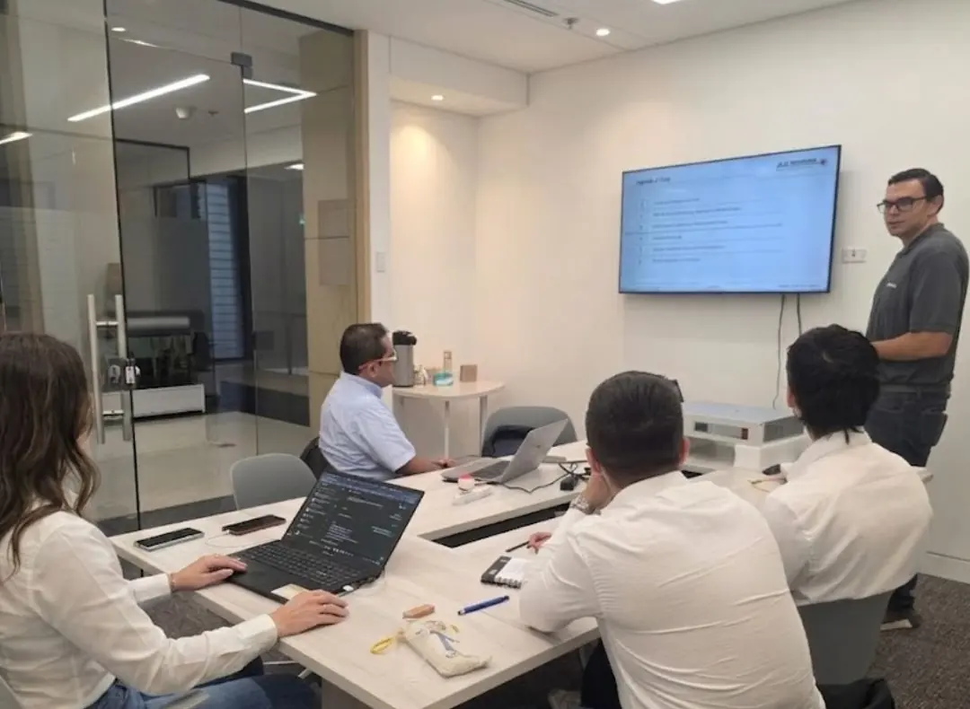 Sala de capacitación: integrantes del equipo de UBORA trabajan en portátiles frente a una pantalla durante la formación en tecnología LHD.